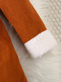 Close-up of orange knit pants with white lining on a textured surface
