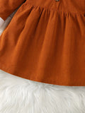 Close-up of a rust-colored corduroy skirt on a white fur surface