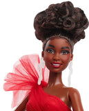 Barbie doll with styled hair and red outfit on a white background