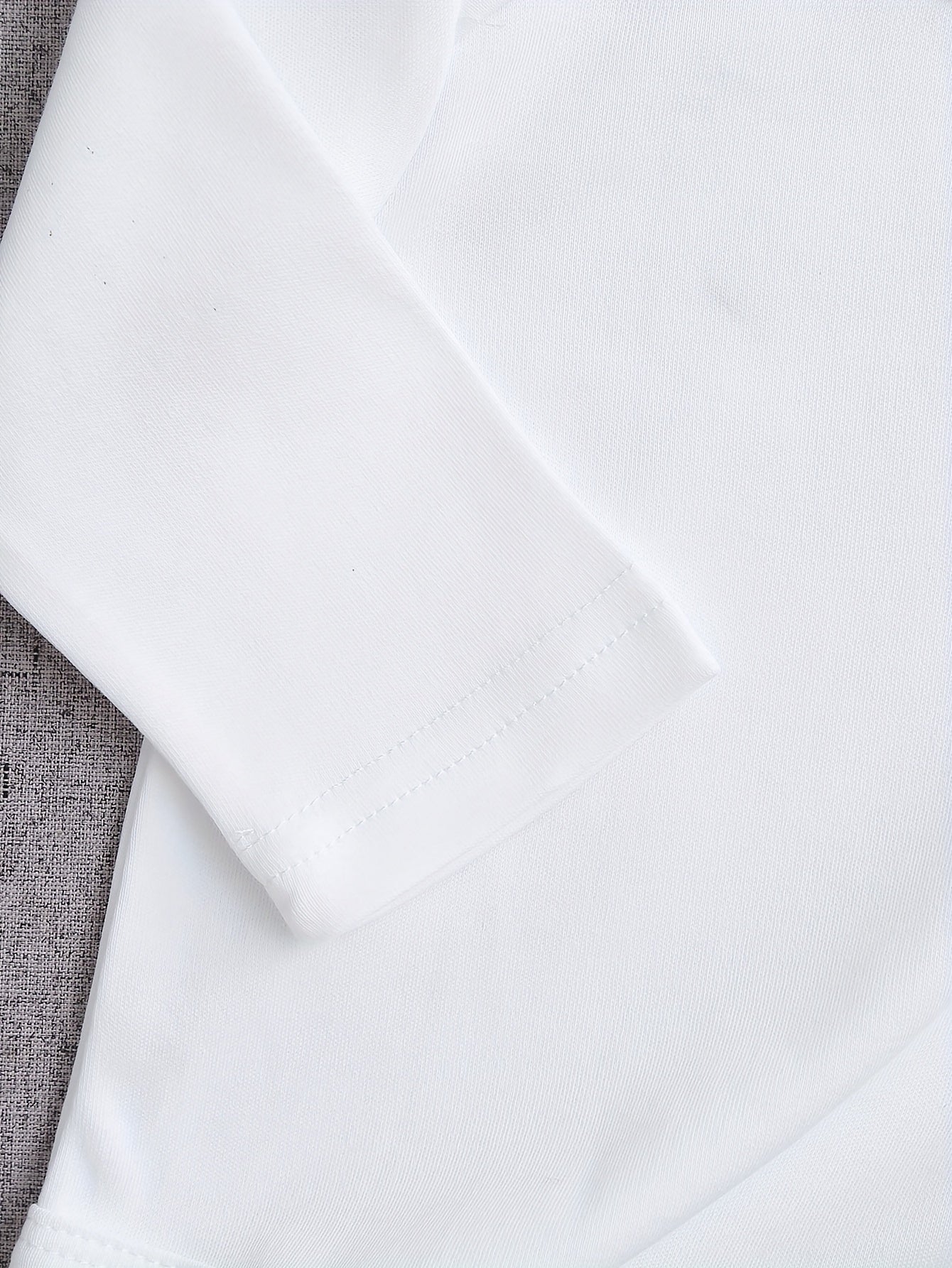 Close-up of a white fabric with a textured gray border