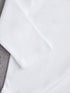 Close-up of a white fabric with a textured gray border