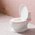 White toilet with pink rim against a pink wall