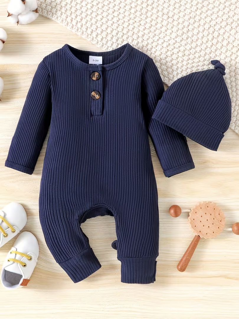 Navy blue ribbed baby romper with matching hat on a wooden surface.