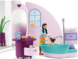 Toy bathroom set with bathtub, shower, and figures in a pink and purple color scheme.