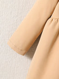 Close-up of beige pants with a textured light gray background